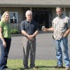 ETC solves sewage challenge for owner of Burnside Community Care Home Kelly Galloway with Owner, Alan MacPhee, and septic installer, Philip Clark (holding bottle of clear effluent)